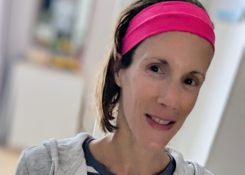 Photo of carly wearing a pink headband and a blue and white stripy top