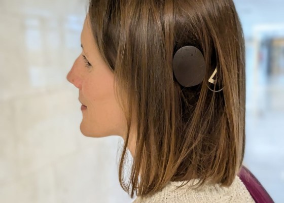 Profile of Carly, wearing her ebony Rondo 3 processor and white jumper.