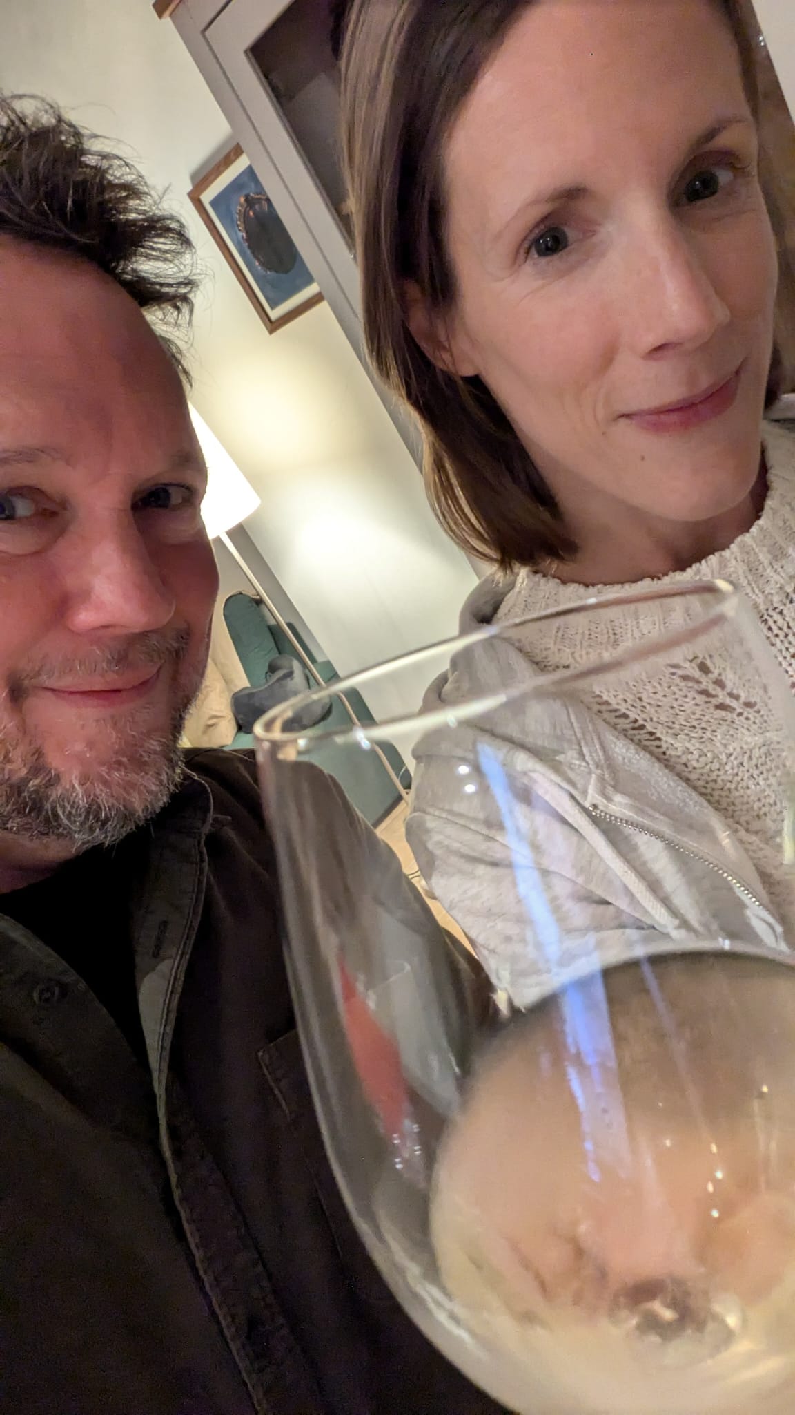 Carly and her partner smiling and clinking glasses of champagne.